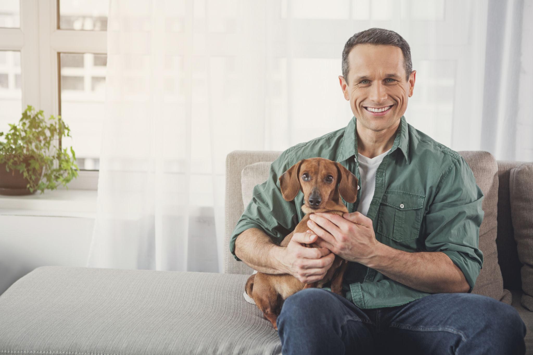 Hombre con su perro junto a una vivienda
